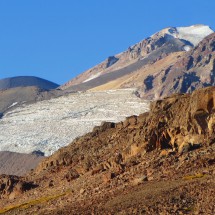Black round shaped Volcan Tinguiririca and icy Azufreras and Fray Carlos in the late evening light